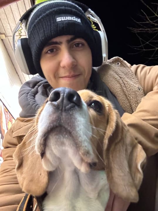 Serhii outdoors in winter with a beagle